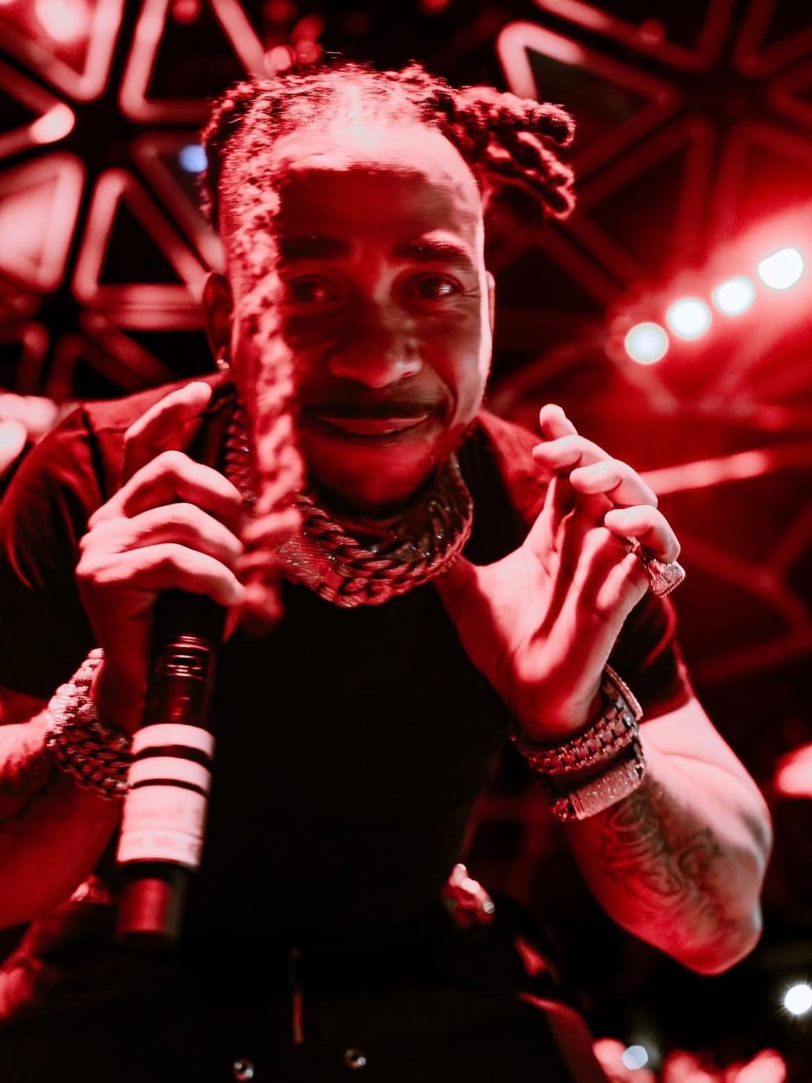 Max B performing under red lights